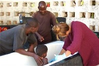 Samantha Ludick cleans boy's burn after treatment from traditional African healer.